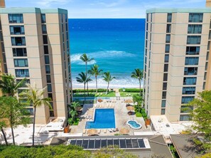 Ein Hotel mit Pool, Palmen und Meerblick.