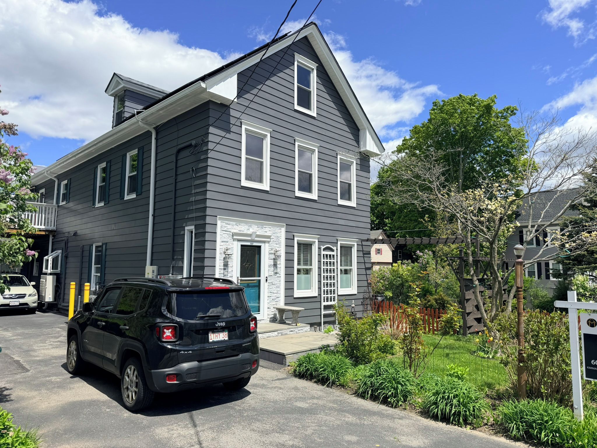 A two-story house with a garage, a driveway, and a parked SUV.