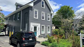 A two-story house with a garage, a driveway, and a parked SUV.
