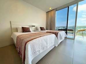 Een hotelkamer met twee bedden, een groot raam met uitzicht en een balkon met een stoel.