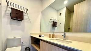 Ein modernes Badezimmer mit Toilette, Waschbecken und Spiegel.
