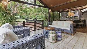 An outdoor patio area with a sofa, chairs, and a dining table. - Vrbo Property (Açu da Torre)