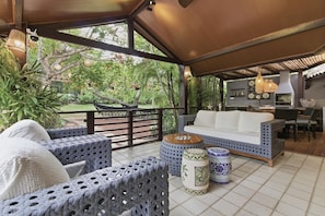 Un área de patio al aire libre con un sofá, sillas y una mesa de comedor.