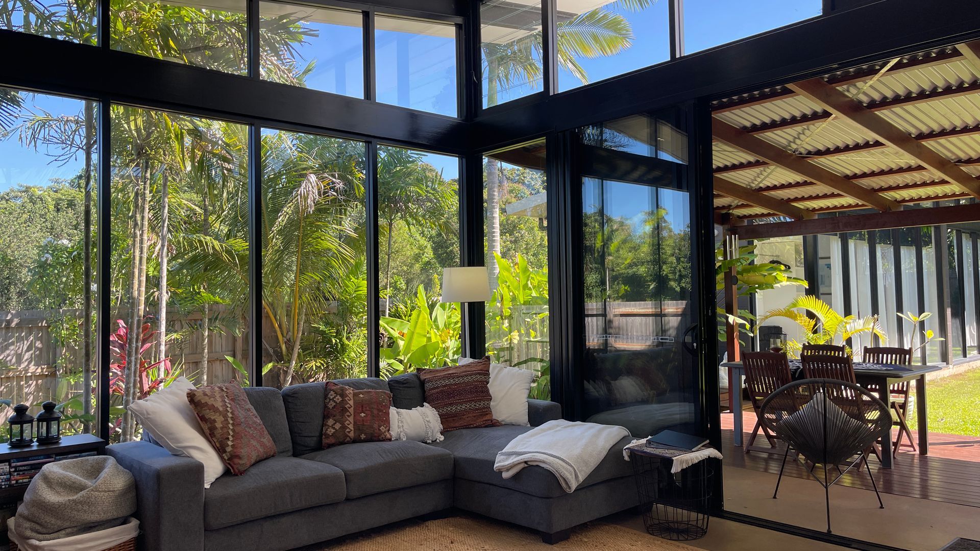 A modern living room with a large sectional sofa, a coffee table, and a dining area with chairs.