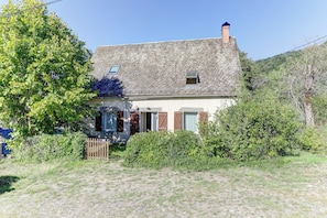 Ein Haus mit einem Stehdach, Holzläden und einem kleinen Fenster.