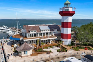 A coastal property with a lighthouse, a dock with boats, and a building with outdoor seating. - Private Pool Paradise in Sea Pines Resort 3BR 3B (Hilton Head Island)
