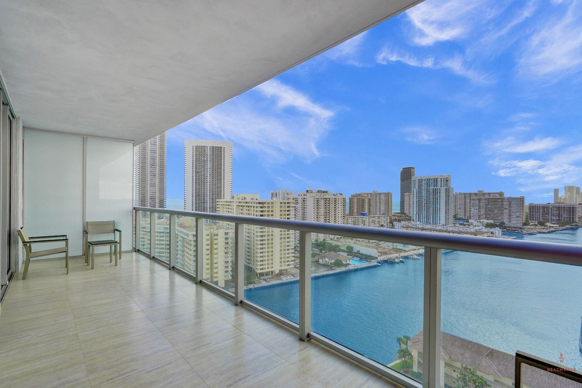 A balcony with a view of a city skyline and a body of water.