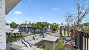 A patio with outdoor furniture, a dining table, and a potted plant. - Furnished Monthly- 3BR Rooftop- East Nashville (Nashville)
