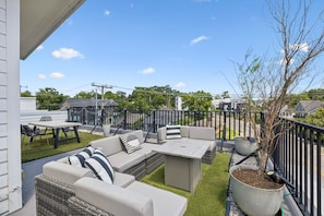A patio with outdoor furniture, a dining table, and a potted plant. - Furnished Monthly- 3BR Rooftop- East Nashville (Nashville)