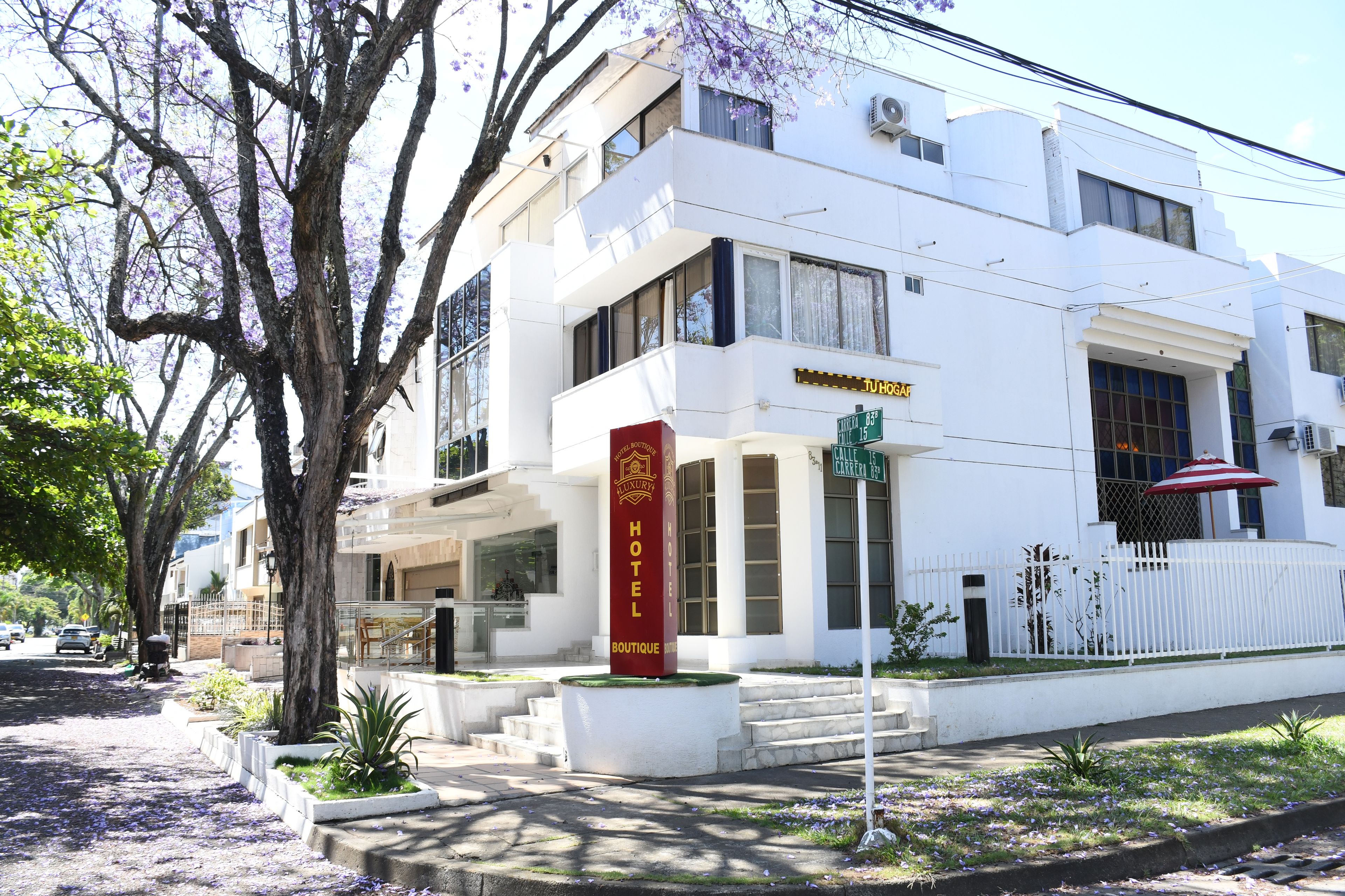 Um edifício branco com uma placa vermelha indicando um hotel e boutique.
