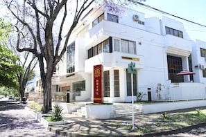 A white building with a red sign indicating a hotel and boutique. - hotel  boutique luxury (Cali)