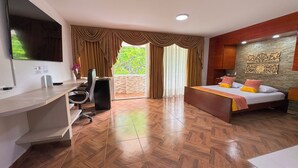 Ein Hotelzimmer mit Bett, Schreibtisch, Stuhl und Fernseher.