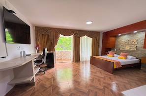Une chambre d’hôtel équipée d’un lit, d’un bureau, d’une chaise et d’un téléviseur.