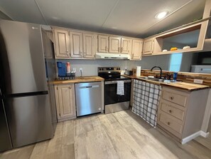 A compact kitchen with a stainless steel refrigerator, a dishwasher, a stove, and a sink. - Luxury Mountain Retreat ~ Ride-In/Ride-Out ATV/UTV Access (Rock)