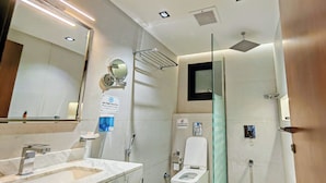Un baño moderno con lavamanos de mármol, inodoro y mampara de vidrio.