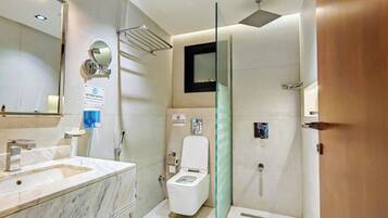 Ein modernes Badezimmer mit Marmorwaschbecken, Toilette und Duschbereich.