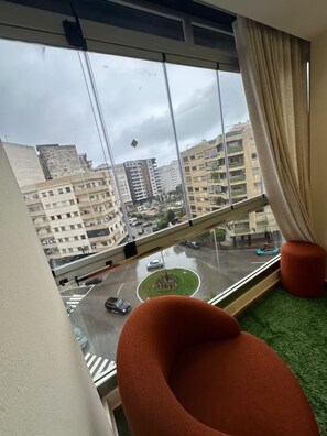 Una habitación con un ventanal que da a una vista panorámica de la ciudad, incluyendo una glorieta y un puente.