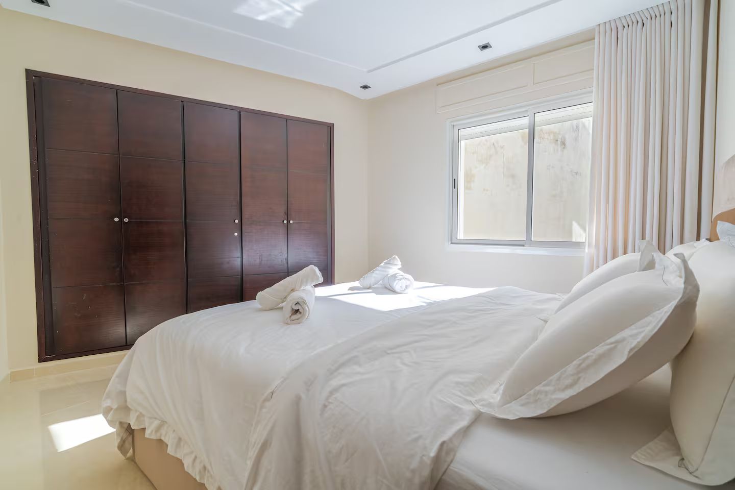 Une chambre à coucher avec un lit, une armoire et une fenêtre.