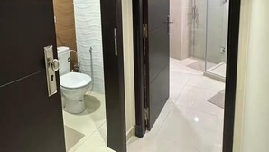 Ein modernes Badezimmer mit Toilette, Dusche und einer Duschkabine aus Glas.