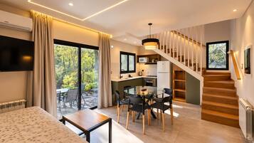 A modern interior with a dining area, kitchen, and staircase.