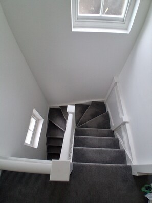 A staircase with a skylight and a small window. - Cottage Two (Dover)