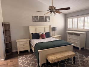 A bedroom with a bed, nightstands, a bench, a ceiling fan, and a window with blinds. - Vaulted ceilings, brand new appliances, overlooking pool/hot tub of complex. (Scottsdale)