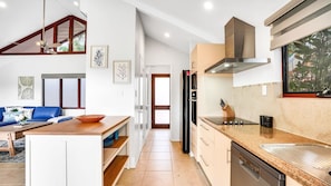 A modern kitchen with a built-in oven, a dishwasher, and a stainless steel range hood.