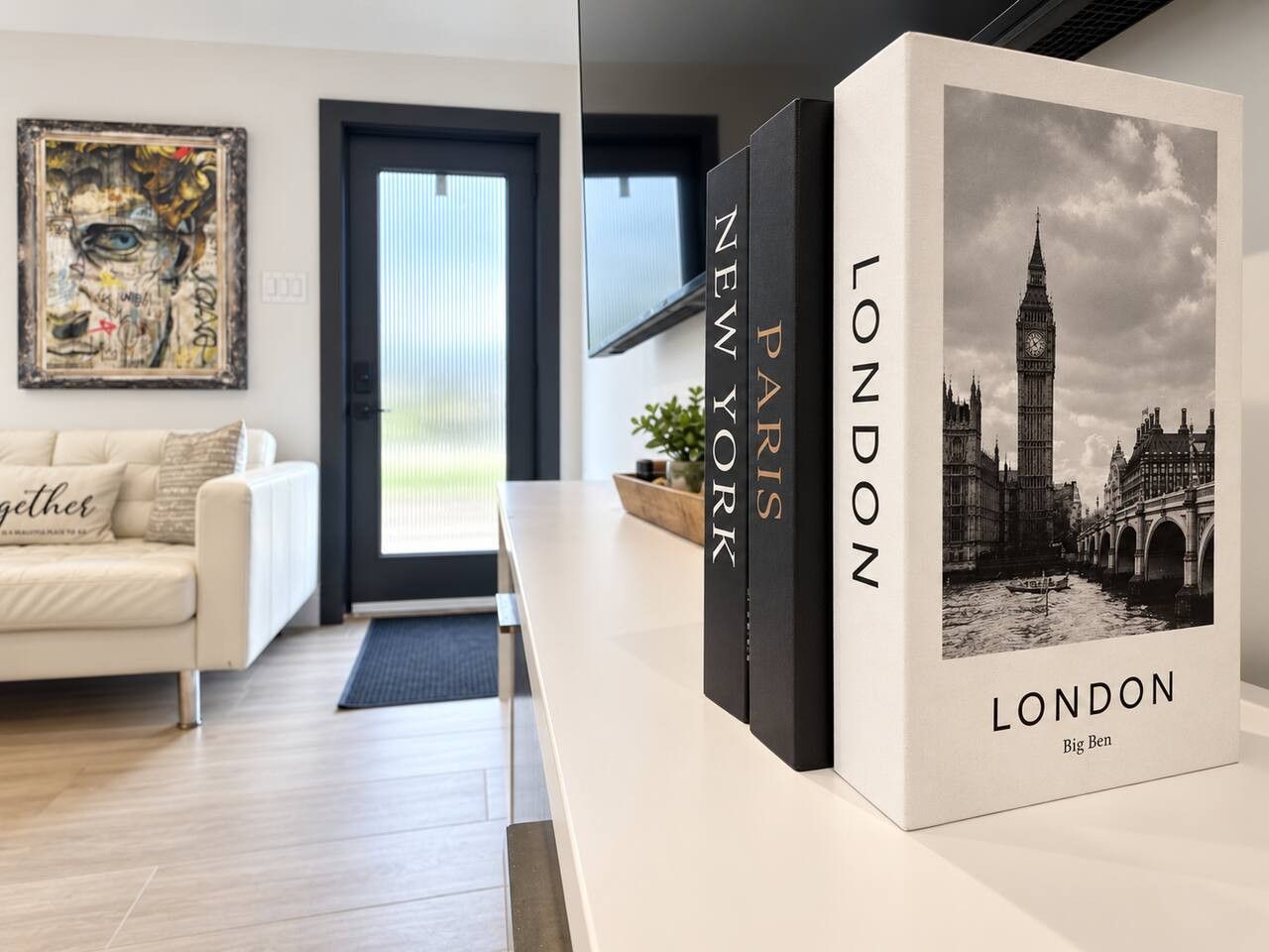 A modern living room with a sofa, a coffee table, and a bookshelf with books titled 'Paris' and 'London'.