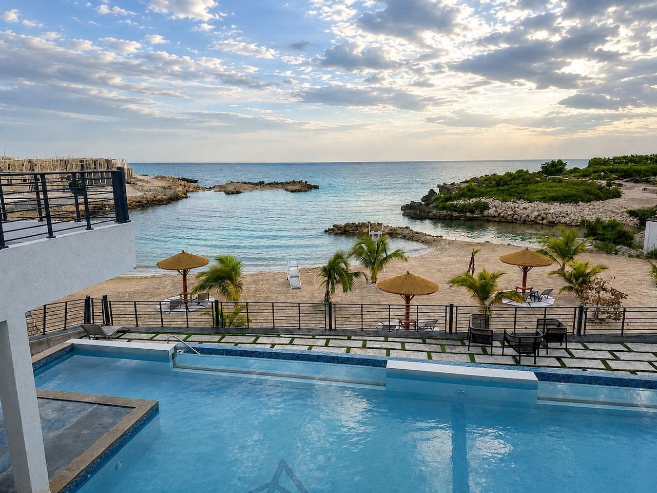 A swimming pool with a view of the beach and ocean.