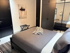 Ein Schlafzimmer mit Bett, Stuhl, Kleiderschrank und einem Bild an der Wand.