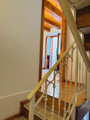 A wooden staircase with white balusters leading to an upper floor. - Tropea Eye (Tropea)