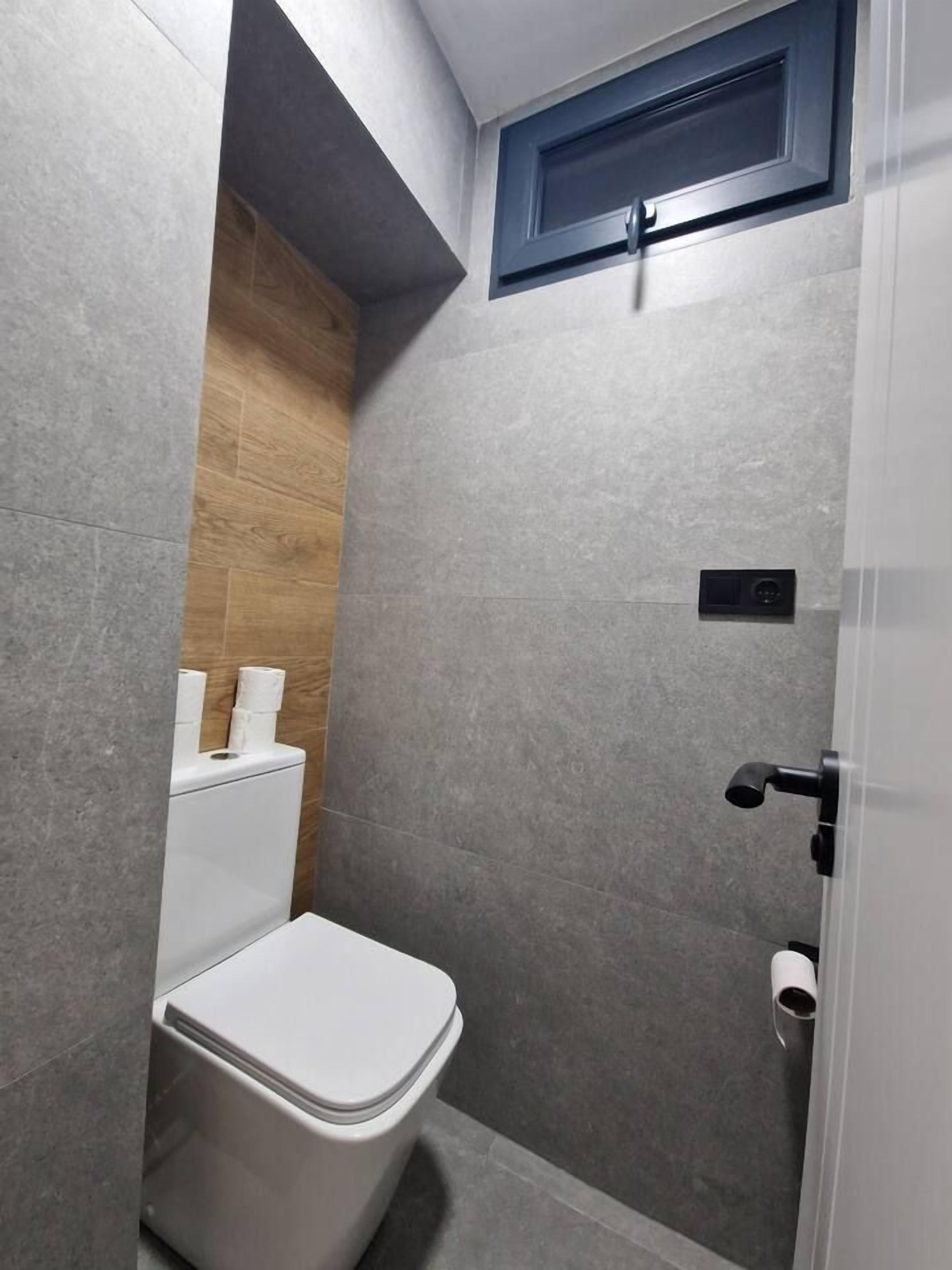 Une salle de bain moderne équipée de toilettes, d’une douche et d’un porte-serviettes.