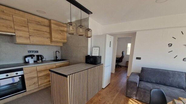 Una cocina moderna con armarios de madera, una isla integrada y un refrigerador.