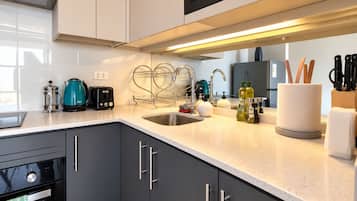 A modern kitchen with a stainless steel sink, a coffee maker, and a knife block.