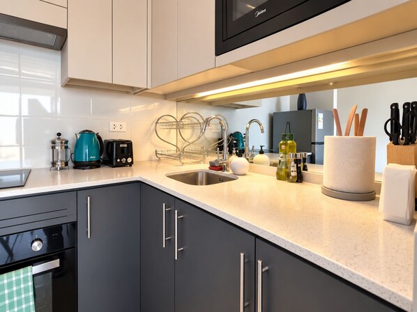 A modern kitchen with a stainless steel sink, a coffee maker, and a knife block.