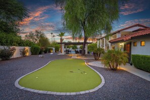 A well-maintained mini-golf course with a putting green, surrounded by a gravel path and landscaped areas. - The Scottsdale Compound: Pool, Putt, Play, Repeat (Scottsdale)