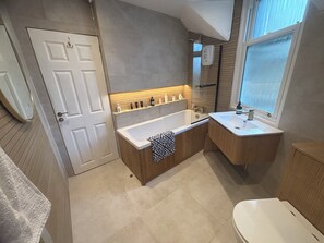 Un baño moderno con bañera, lavamanos y retrete.