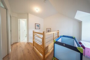 A room with a bunk bed, a desk, and a door leading to another room. - Petit coin de paradis - charmante maison jardin (Quiberon)