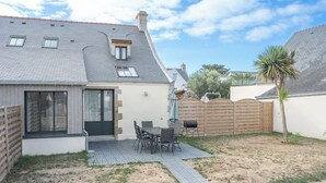 A residential property with a patio, a dining area, and a fenced backyard. - Petit coin de paradis - charmante maison jardin (Quiberon)