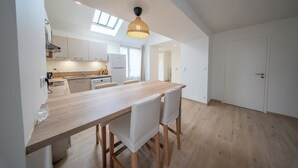 A modern kitchen with a wooden countertop, white cabinets, and a skylight. - Petit coin de paradis - charmante maison jardin (Quiberon)