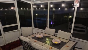 A dining area with a table and chairs, a ceiling light fixture, and a 'No Smoking' sign. - My Paradise, a 4-bedroom Home with Hot Tub & Swimming Pool in Soothing Pensacola (Pensacola)