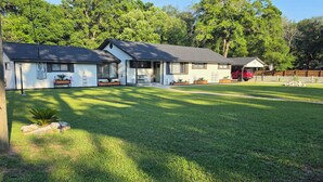 A residential property with a well-maintained lawn, a two-story house, and a red vehicle parked in the driveway. - My Paradise, a 4-bedroom Home with Hot Tub & Swimming Pool in Soothing Pensacola (Pensacola)