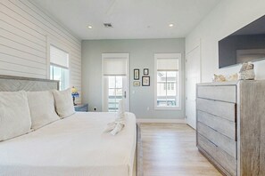 Ein Schlafzimmer mit einem Bett, einem Schminktisch und einem Fernseher.