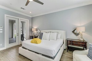 A bedroom with a bed, bedside tables, a chair, and a ceiling fan. - Palmilla Beach Resort-137 Palmilla Circle Unit 101 (Port Aransas)