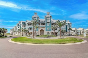 A large, multi-story hotel with a central courtyard and a well-maintained lawn. - Palmilla Beach Resort-137 Palmilla Circle Unit 106 (Port Aransas)