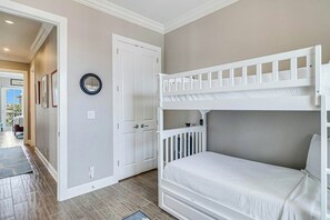 A room with a bunk bed, a door, and a wall-mounted clock. - Palmilla Beach Resort-137 Palmilla Circle Unit 201 (Port Aransas)