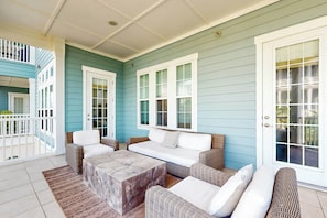 A covered porch with wicker furniture and a stone coffee table. - Palmilla Beach Resort-137 Palmilla Circle Unit 204 (Port Aransas)