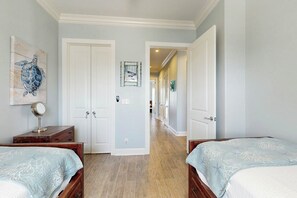 A hotel room with two beds, a hallway leading to another room, and a painting on the wall. - Palmilla Beach Resort-137 Palmilla Circle Unit 206 (Port Aransas)