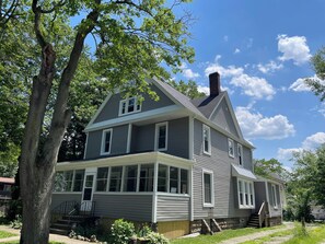 A two-story house with a front porch, a chimney, and a 'No Parking' sign. - Crosby's Comfort Nest - 40in TV in every bedroom (Akron)