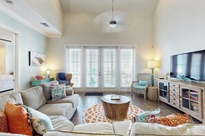 A living room with a sofa, armchairs, a coffee table, a TV, and a fireplace. - Palmilla Beach Resort-137 Palmilla Circle Unit 302 (Port Aransas)